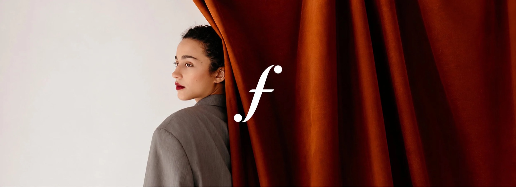Finerminds: a woman beside a rust-red curtain with the italic f mark